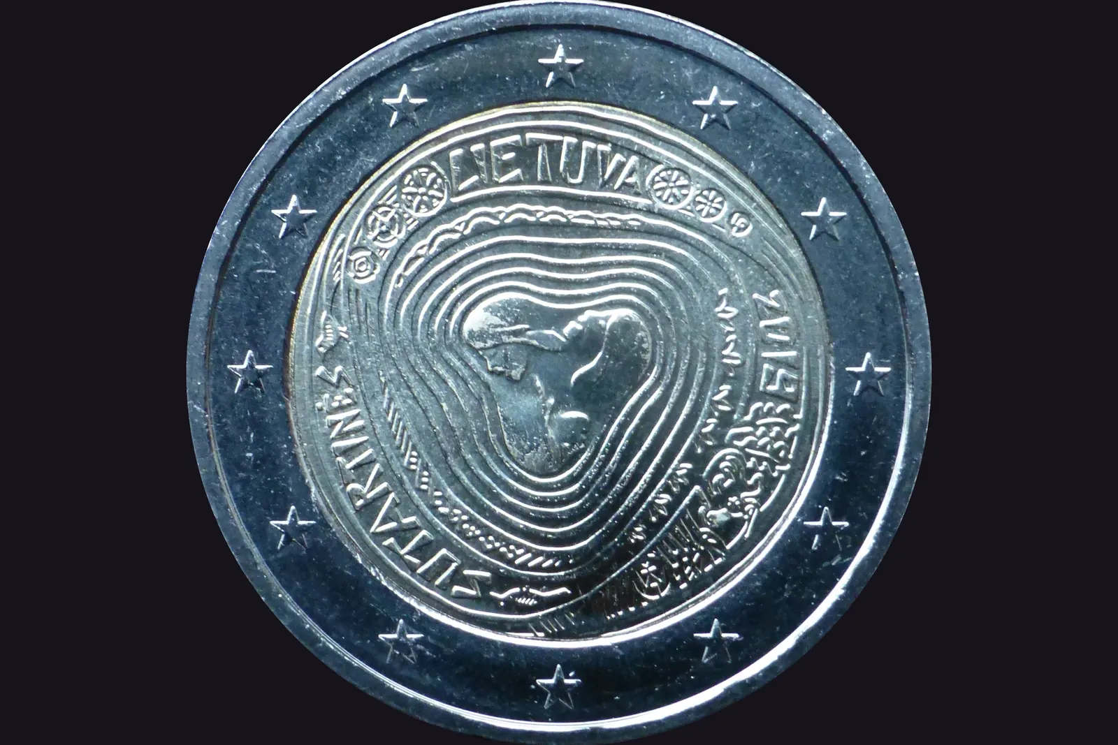 Une 2 € commémorative de Lituanie (2019, chants sutartinės) : la face nationale lituanienne est libre de droits, contrairement à celles de la France, de Monaco ou du Vatican.