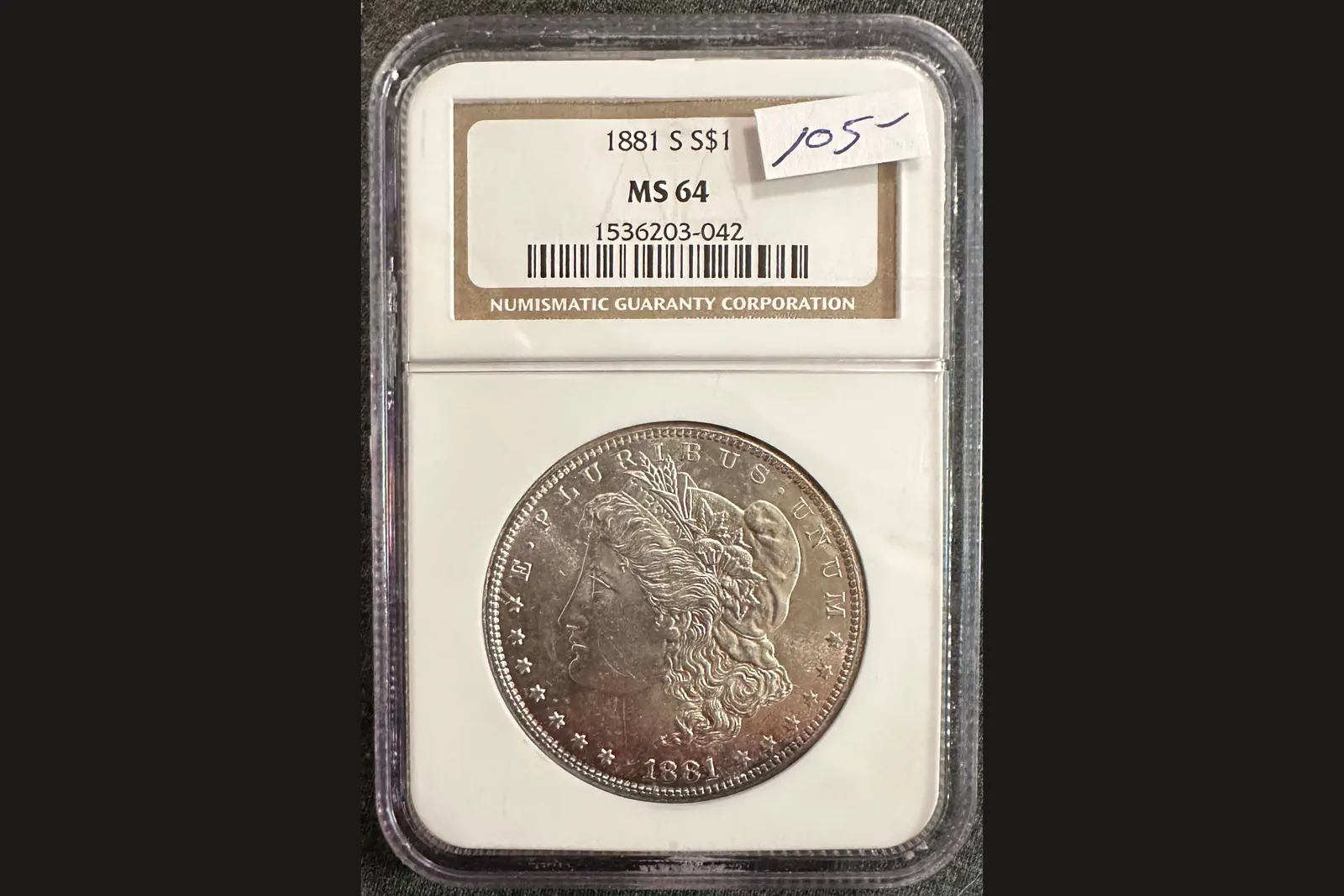 Une pièce « gradée » : dollar américain de 1881 scellé sous coque par la société NGC, note MS 64 sur l'étiquette.